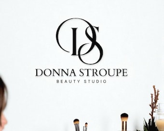 May include: A minimalist logo for "Donna Stroupe Beauty Studio" in black, featuring intertwined initials "DS" above the business name. The image includes makeup brushes and greenery in glass containers, suggesting a beauty and wellness theme.
