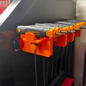 May include: A set of Gearwrench hex keys displayed in an orange holder. The tools feature black and grey handles with orange detailing. The holder is bright orange and mounted on a black surface.