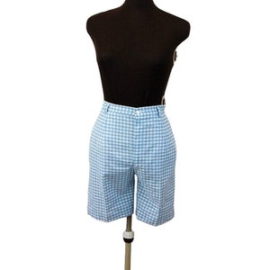 May include: Light blue and white gingham shorts featuring a high-waisted design with a button closure at the center front, belt loops along the waistband, and a tailored fit that extends to just above the knee, displayed on a mannequin torso.