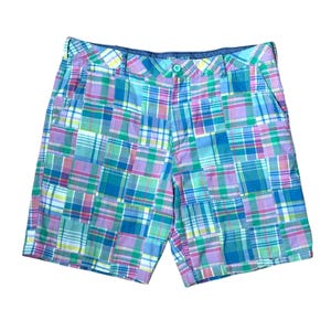 May include: Shorts featuring a patchwork design of various plaid patterns in shades of light blue, teal, purple, pink, and white. The garment includes a waistband with belt loops, a single button closure, and a zippered fly front opening.