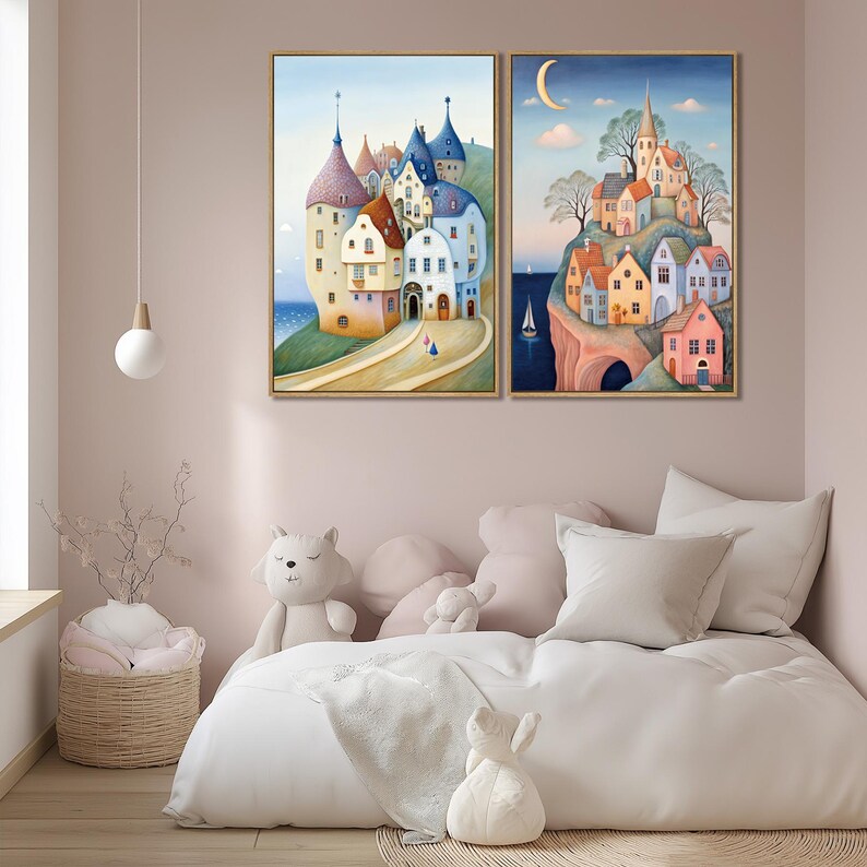 May include: Two framed watercolor paintings depict whimsical European villages. One shows a coastal town with colorful buildings and a road. The other features a village on a cliff with a sailboat in the sea and a crescent moon in the sky.