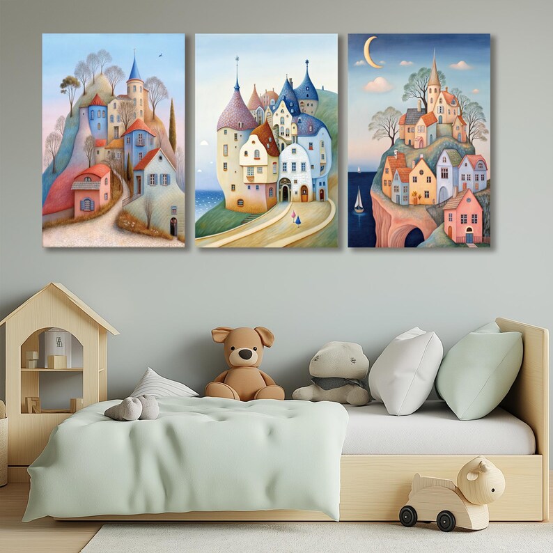 May include: Three canvas art prints depicting whimsical European villages. The artwork features colorful buildings, winding roads, and a serene landscape. The paintings are displayed above a child's bed with a wooden frame and soft toys.
