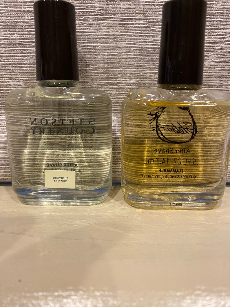 Pode incluir: Duas garrafas de vidro transparente de aftershave. A garrafa &agrave; esquerda &eacute; etiquetada como "Country Gentleman" e a garrafa &agrave; direita &eacute; etiquetada como "Stetson" com um logotipo de ferradura. Ambas as garrafas s&atilde;o de 3,7 fl oz e s&atilde;o etiquetadas como "Inflamavel".
