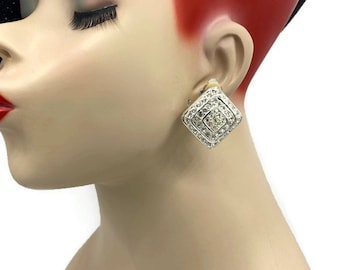 May include: A pair of silver tone clip-on earrings with a square design. The earrings are set with clear rhinestones.