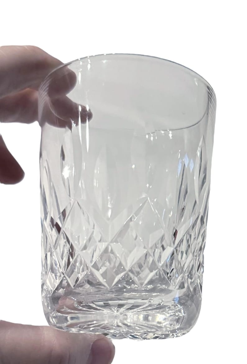Puede incluir: Un vaso de cristal transparente con un dise&ntilde;o de cristal tallado. El vaso tiene un fondo redondeado y lados rectos.