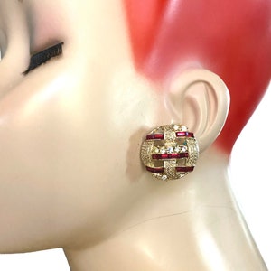 Op de afbeelding: Gouden clip-on oorbellen met een geometrisch ontwerp met heldere en rode strass stenen.