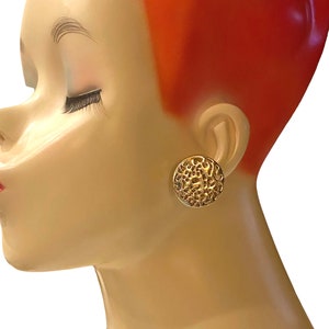 May include: Gold tone clip-on earrings with a textured circular design.