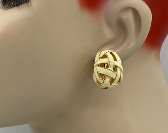 May include: A pair of gold tone clip-on earrings with a white woven design.