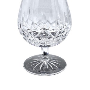 May include: A clear crystal brandy snifter with a cut glass design. The snifter has a round bowl and a short stem with a wide base.