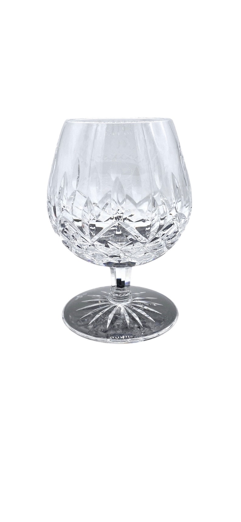 May include: A clear crystal brandy snifter with a cut glass design. The snifter has a round bowl and a short stem with a wide base.