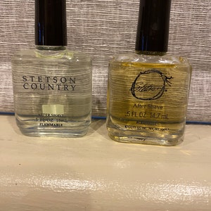 Pode incluir: Duas garrafas de vidro transparente de aftershave. A garrafa &agrave; esquerda est&aacute; etiquetada "Stetson Country After Shave 5 fl oz 15 ml Flammable". A garrafa &agrave; direita est&aacute; etiquetada "Stetson After Shave 0.5 fl oz 14.7 ml Flammable Coty US Inc., NY, NY 10017".