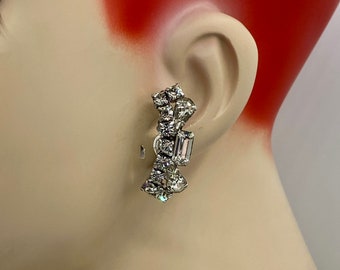May include: Silver tone earrings with a cluster of clear rhinestones and a larger rectangular rhinestone in the center.