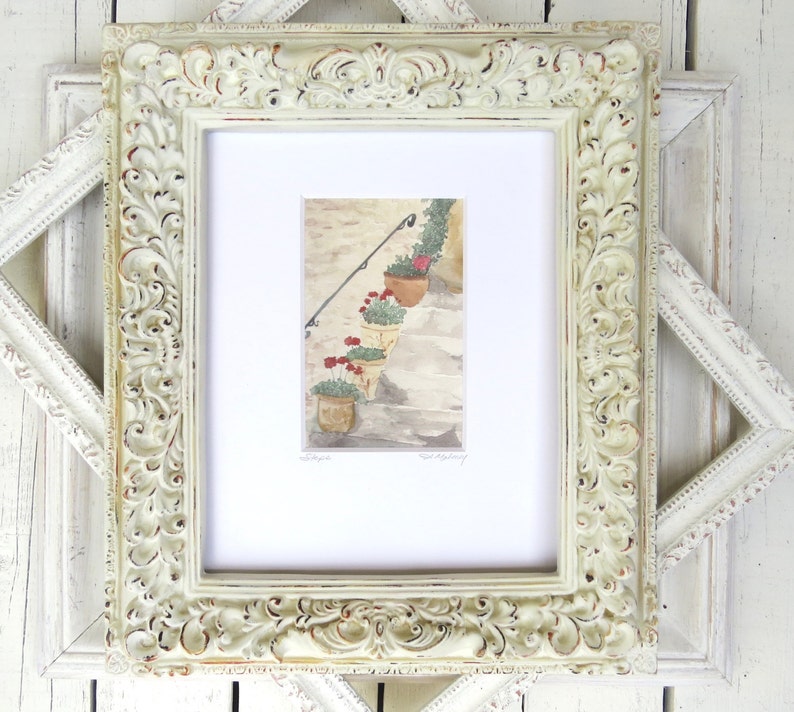 May include: A framed watercolor painting of a set of stairs with potted plants and red flowers. The frame is white with ornate detailing.