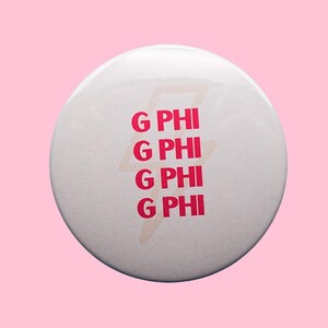 May include: A white button with the text "G PHI" in pink, repeated four times, with a pink lightning bolt design behind the text. The button is set against a pink background.