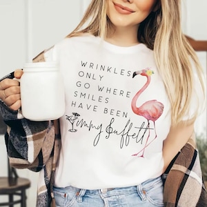 May include: White t-shirt with a pink flamingo and the text "Wrinkles only go where smiles have been. Jimmy Buffett".