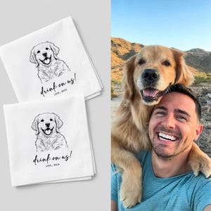 May include: Two white kitchen towels with a black line drawing of a golden retriever dog. The towels have the text "drink on us!" and "LOVE, BUCK" in a handwritten font. The towels are stacked on top of each other.