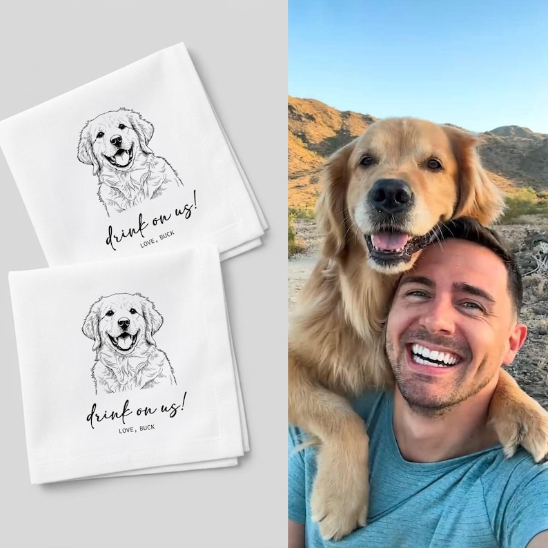 May include: Two white kitchen towels with a black line drawing of a golden retriever dog. The towels have the text "drink on us!" and "LOVE, BUCK" in a handwritten font. The towels are stacked on top of each other.