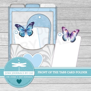 May include: A light blue card folder with tabs, featuring a butterfly design. The folder includes white card inserts and a heart-shaped cutout. The text "JUNK JOURNALS BY CAZ" and "FRONT OF THE TABS CARD FOLDER" are visible.