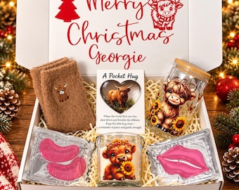 May include: A gift box containing a pair of brown knit mittens with a highland cow patch, a glass tumbler with a highland cow and sunflower print, a candle with a highland cow graphic, and two pink lip-shaped under-eye gel patches.