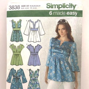 May include: Simplicity sewing pattern 3838 for a tunic with a split neckline and empire waist. The envelope displays six variations of the top with different sleeve lengths and floral or solid fabric patterns, including size U5 16, 18, 20, 22, 24.