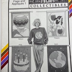 May include: Vintage sewing pattern titled "Flags and Appliqués 1" by Ann Person Collectibles. The pattern features designs of a hot air balloon, flowers, a birthday cake, and a globe. The model in the image is wearing a sweater with a globe design.