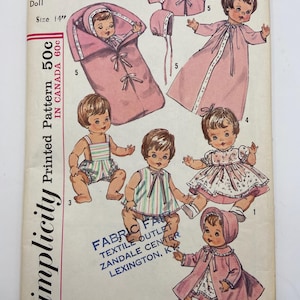 May include: Vintage Simplicity doll pattern, size 35.5 cm. The pattern features illustrations of a doll in various outfits, including a sleeping bag, dress, and coat. The pattern is marked with the price and location.