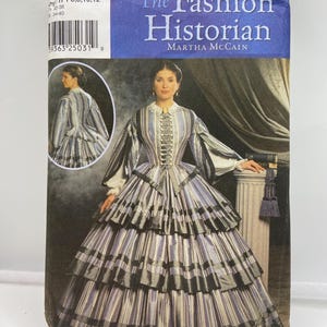 Może przedstawiać: Wzór szycia Simplicity numer 3761, zatytułowany "The Fashion Historian" autorstwa Marthy McCain. Wzór przedstawia kobietę w pasiastych sukniach z warstwową spódnicą i długimi rękawami. Rozmiary: 6, 8, 10, 12.