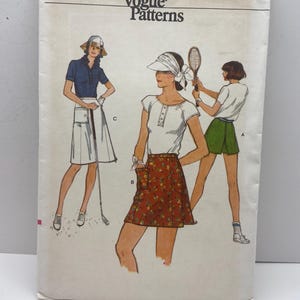 Op de afbeelding: Vintage Vogue Patterns naaipatroonpakket. Het pakket bevat illustraties van vrouwen in sportkleding, waaronder tennis- en golfoutfits. Het pakket is wit met de tekst "Very Easy Vogue Patterns" en het nummer "9515".