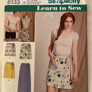 May include: A Simplicity sewing pattern for a wrap skirt. The pattern includes instructions for making four different styles of skirts, including a yellow skirt, a blue and white striped skirt, a patterned skirt, and a floral skirt. The pattern is for sizes 6-18 and includes instructions for making a skirt with a tie belt.