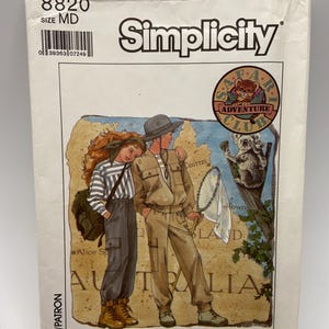 May include: Simplicity pattern envelope featuring illustrations of two people in safari attire, a map of Australia, and a "Safari Adventure Club" logo. The envelope has the number "8820" and the size "MD" printed on it.