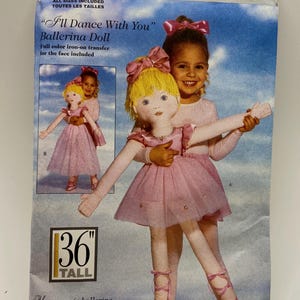 May include: A vintage Butterick sewing pattern for a ballerina doll. The doll is 91 cm tall and wears a pink dress and ballet shoes. The pattern includes a full-colour iron-on transfer for the face.