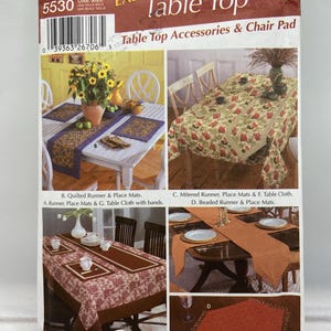 Op de afbeelding: Een Simplicity-patroon voor tafelaccessoires en stoelkussens. De verpakking toont afbeeldingen van tafels met tafellopers, placemats en tafelkleden. Ontwerpen omvatten gewatteerde, verstek- en kralenstijlen. De verpakking is gemarkeerd met "Easy!" en heeft nummer 5530.