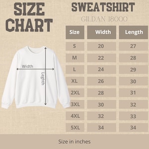 May include: A white sweatshirt with a size chart. The chart shows measurements in inches for width and length, ranging from size S to 5XL. The sweatshirt is a Gildan 18000 model.