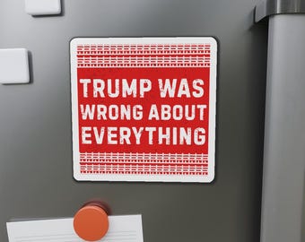 May include: A rectangular magnet with a red background and white text that reads "TRUMP WAS WRONG ABOUT EVERYTHING." The magnet has a distressed, vintage look and is attached to a gray surface with other magnets.