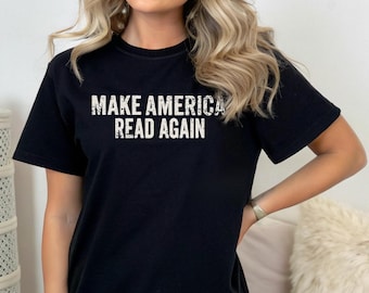 Puede incluir: Camiseta negra con el texto blanco "MAKE AMERICA READ AGAIN". El texto tiene un aspecto desgastado y vintage. La camiseta es de cuello redondo.