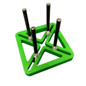 Puede incluir: Un objeto verde brillante de forma geométrica con cuatro varillas negras aseguradas por tuercas plateadas. Las varillas están espaciadas uniformemente y se extienden hacia arriba. El objeto está sobre un fondo blanco liso.