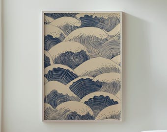 May include: Framed art print featuring a repeating pattern of stylized ocean waves in navy blue and beige. The artwork is displayed on a white wall above a wooden table with white vases.
