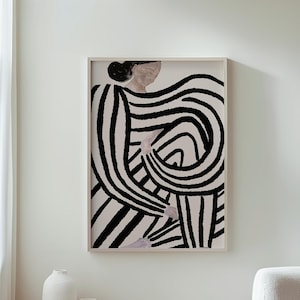 May include: Framed art print featuring an abstract figure with bold black and white striped patterns. The artwork is displayed in a light wooden frame, adding a touch of modern decor. The print is mounted on a white wall, with a wooden table and white vases in the foreground.