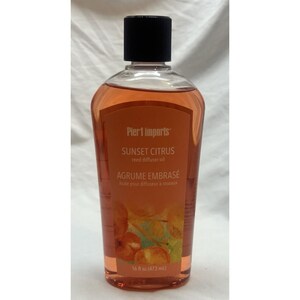 Könnte beinhalten: Eine durchsichtige Kunststoffflasche gefüllt mit orangefarbenem Sunset Citrus Duftöl für Diffuser. Das Etikett zeigt den Text Pier 1 Imports, SUNSET CITRUS, reed diffuser oil, AGRUME EMBRASÉ und 16 fl oz (473 ml). Mit schwarzem Schraubverschluss.