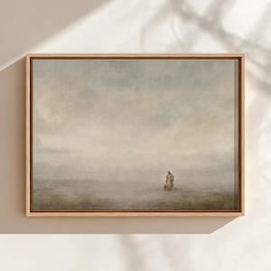 Könnte beinhalten: Ein gerahmter Landschaftskunst-Druck mit einer einzelnen Figur in einer nebligen, gedämpften Farbszene. Das Kunstwerk hat eine weiche, malerische Qualität mit einem hellen Holzrahmen, wodurch eine ruhige Atmosphäre entsteht. Die Farbpalette umfasst gedämpfte Grün-, Blau- und Brauntöne.
