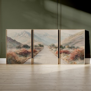 May include: Set of three framed landscape art prints. Each print features a path leading towards mountains, with text at the top. The text reads "Ask", "Seek", and "Knock". The artwork has a muted color palette.