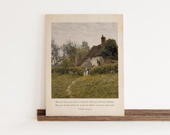 May include: A framed print featuring a pastoral landscape with a thatched-roof cottage, a path, and figures. The artwork has a vintage aesthetic with soft colors and a serene atmosphere. Text at the bottom reads, "May the Lord cause you to flourish... Psalm 115:14-15."