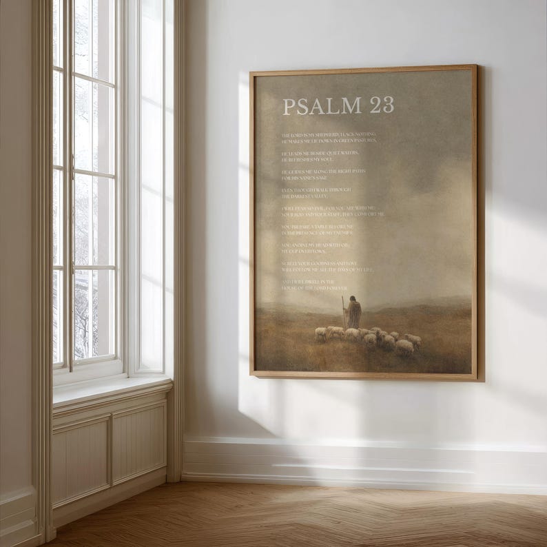 May include: A framed print featuring the text "Psalm 23" in white. The artwork depicts a shepherd with a staff and a flock of sheep in a field. The background has a muted, earthy color palette with a soft, hazy effect.