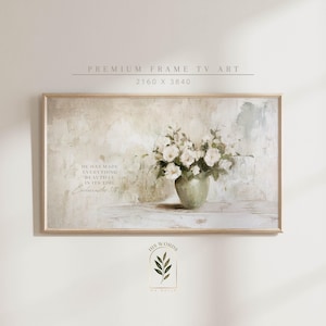 Könnte beinhalten: Gerahmter Kunstdruck mit einem Stillleben aus weißen Blumen in einer grünen Vase. Das Kunstwerk hat eine neutrale Farbpalette und einen strukturierten, malerischen Stil. Der Text lautet: "HE HAS MADE EVERYTHING BEAUTIFUL IN ITS TIME".