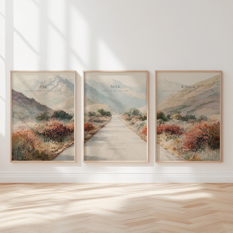 May include: Set of three framed landscape art prints. Each print features a watercolor painting of a road leading through a valley, with text at the top. The text on each print reads "Ask", "Seek", and "Knock". The prints are in wooden frames.