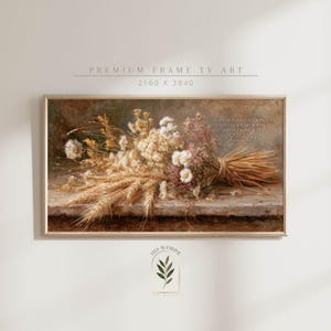 Op de afbeelding: Een ingelijste digitale kunstdruk met een stilleven van gedroogde bloemen en tarwe. Het kunstwerk toont een boeket van beige, witte en roze bloemen met de tekst "THOSE WHO SOW IN TEARS SHALL REAP WITH SHOUTS OF JOY".