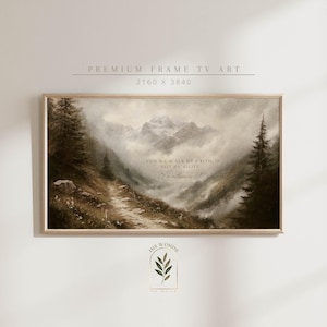 May include: A framed landscape print depicting a mountain scene with a path leading towards the mountains. The artwork has a muted colour palette with text that reads "FOR WE WALK BY FAITH, NOT BY SIGHT". The frame is a light brown colour.