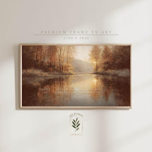 Puede incluir: Una impresión artística enmarcada que representa una serena escena lacustre con árboles y una puesta de sol. La obra de arte tiene tonos cálidos y terrosos e incluye el texto "AS WATER REFLECTS THE FACE, SO ONE'S LIFE REFLECTS THE HEART" y "Proverbios 27:19".