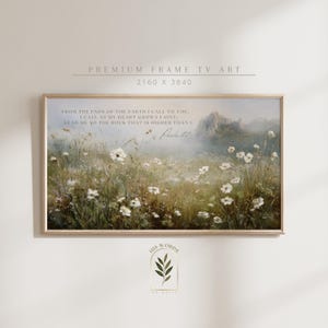 May include: A framed landscape print featuring a field of white flowers and a mountain in the background. The artwork includes text from Psalm 61:2. The frame is a light wood color. The overall theme is nature and spirituality.