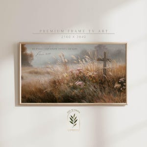 May include: Framed landscape art print featuring a cross in a field of tall grass and wildflowers. The artwork has a muted color palette with text that reads "Be still, and know that I am God. Psalm 46:10."